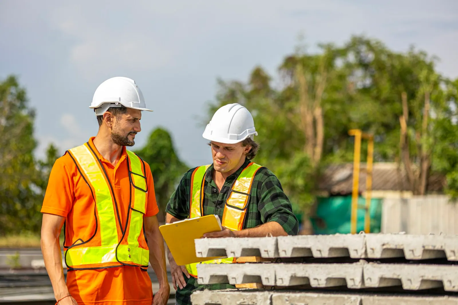 Construction workers review plans on site Two male engineers from different cultures work together in a floor making factory. Senior supervisor discusses with his engineer or cowor. What a mold remediation business hire must learn in the first weeks for a small operation